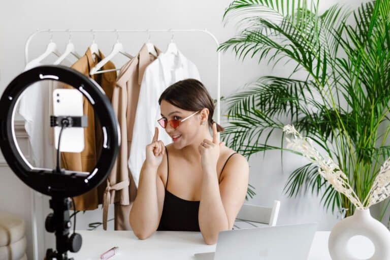 girl with sunglasses recording a video with phone